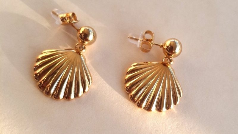 Gros plan sur boucles d’oreilles coquillage dorées