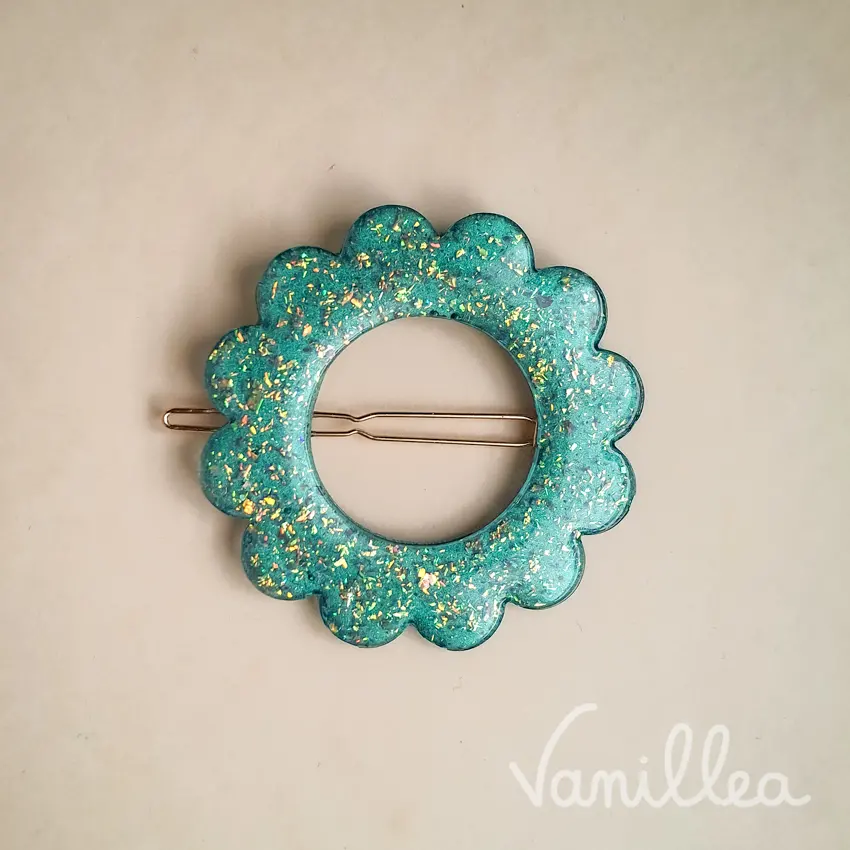 Barrette fleur turquoise pailletée avec pince dorée au dos.