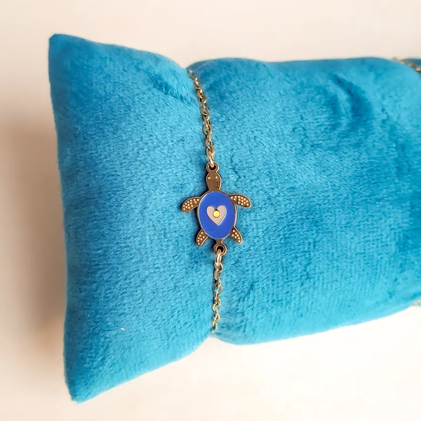 Vue latérale du bracelet enfant tortue doré avec chaîne fine, fermoir mousqueton et chaînette d’extension.