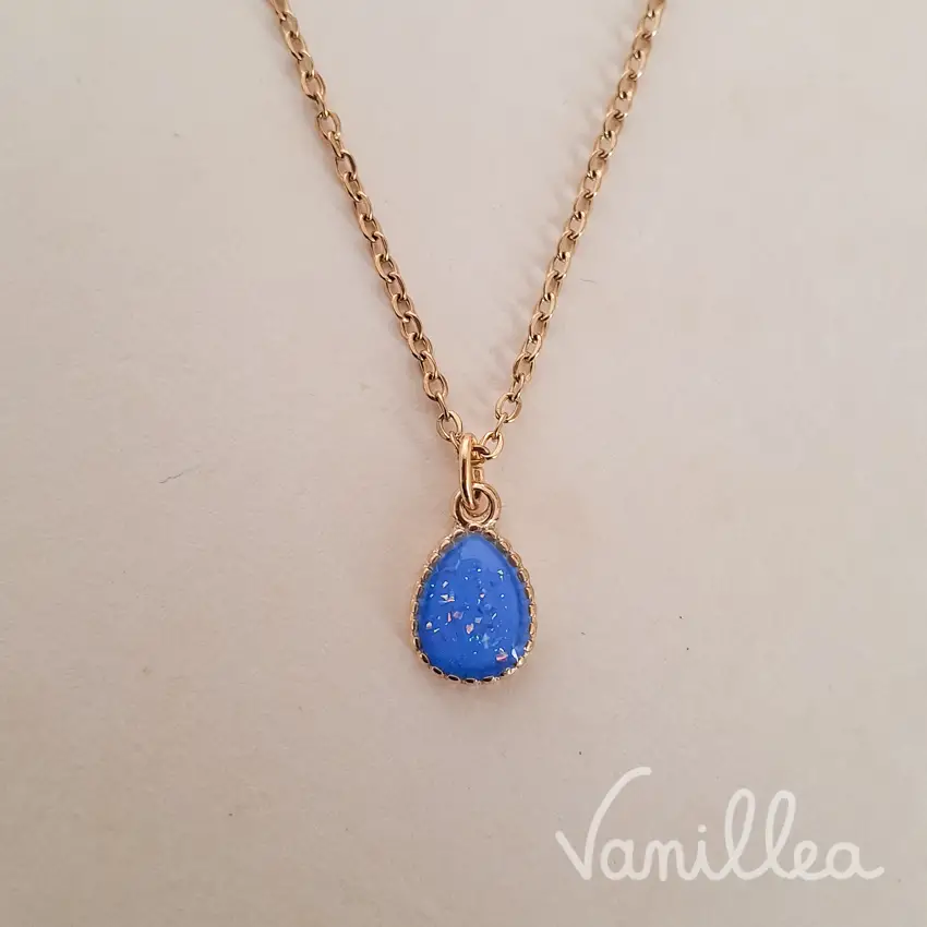 Collier bleu goutte fin porté avec chaîne dorée