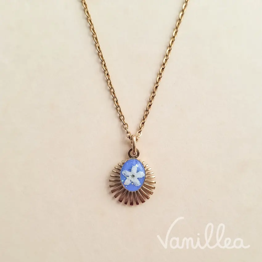 collier soleil myosotis doré avec pendentif floral bleu pastel
