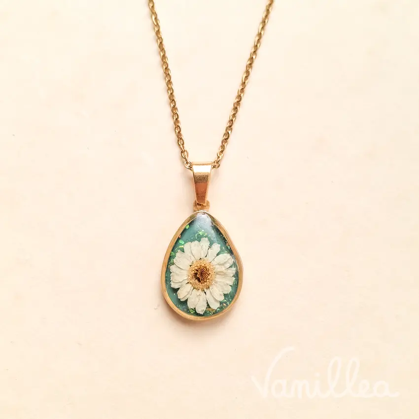 Collier goutte fleur de camomille naturelle douce fond vert bleu