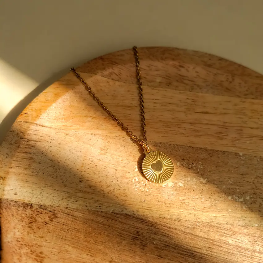 Collier médaille cœur acier inoxydable doré effet soleil.