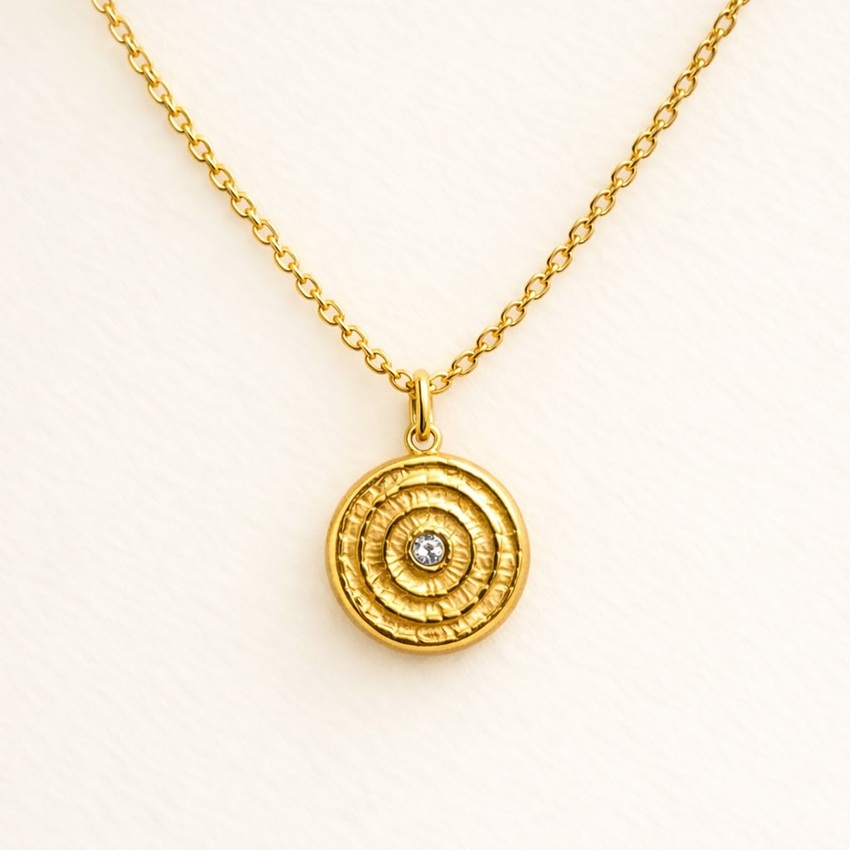 Collier médaille spirale dorée en acier inoxydable sur fond clair