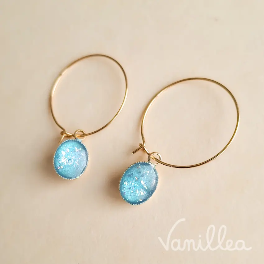 Créoles fines dorées avec pendentif bleu vues de côté