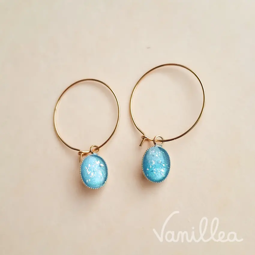 Créoles dorées avec pendentif cabochon bleu azur pailleté.