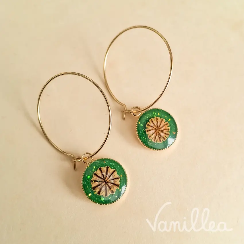Créoles dorées avec pendentifs coquelicot en fleurs naturelles sur fond vert