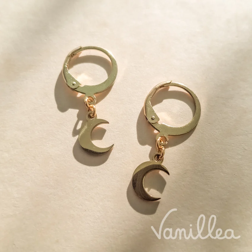 Boucles d'oreilles dormeuses dorées avec petits pendentifs en forme de croissant de lune