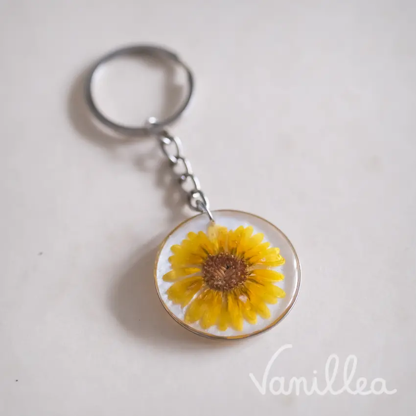 Porte-clés rond camomille jaune vue de côté avec anneau argenté