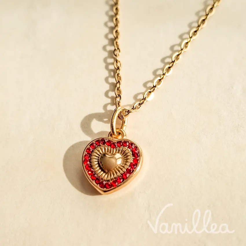 Pendentif cœur doré et rouge de profil avec anneau de suspension