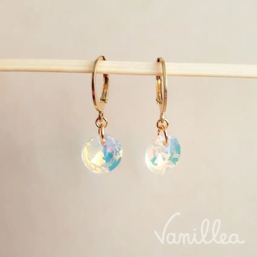 Vue frontale des boucles dormeuses cristal irisé dorées, avec fermoir sécurisé et pendentif rond facetté.