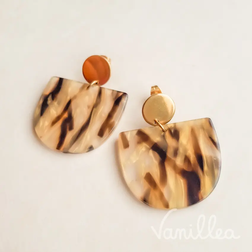 Vue frontale des puces d’oreilles acétate écaille été, avec base dorée en acier inoxydable et forme arrondie lumineuse.