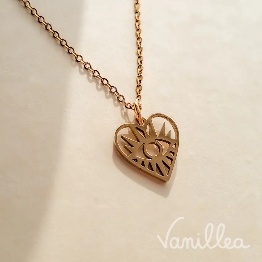 détail du pendentif œil doré minimaliste en forme de cœur