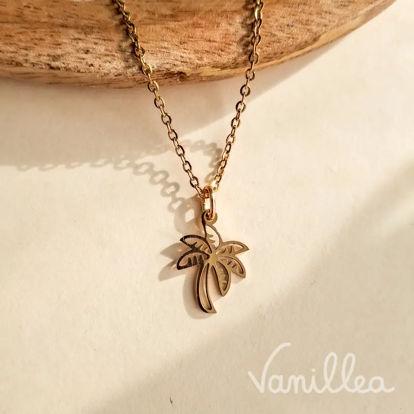 Collier palmier doré en acier inoxydable sur fond clair