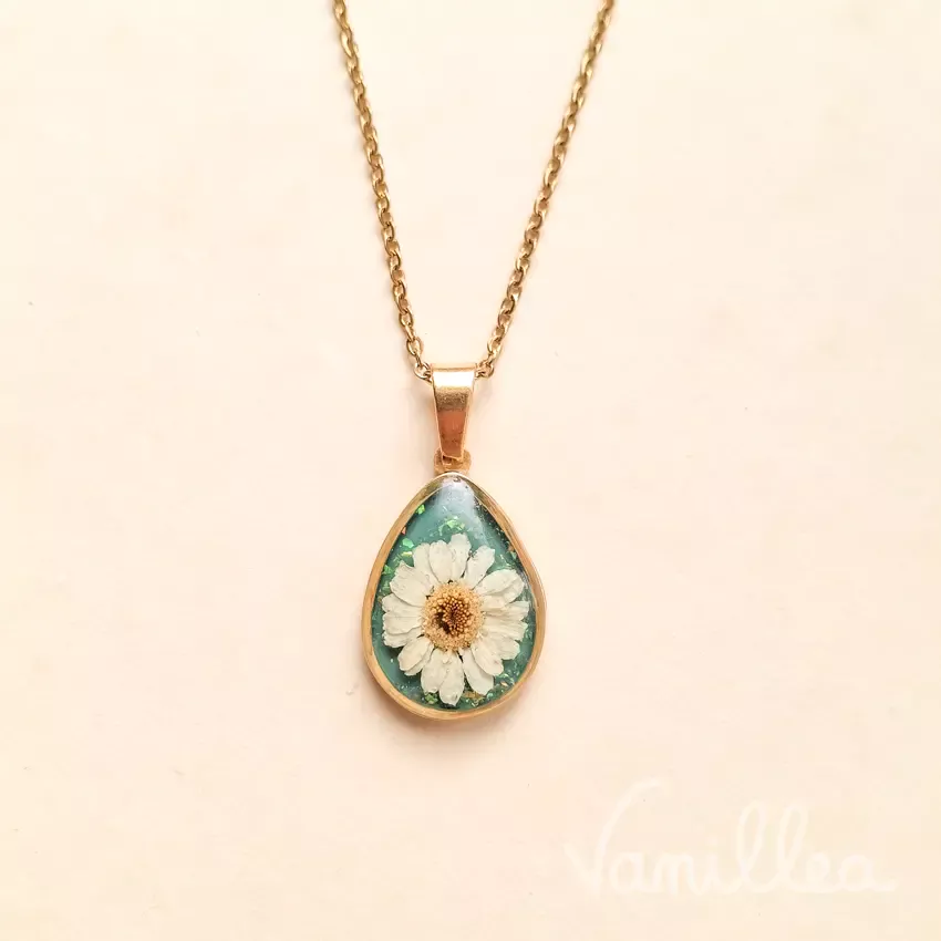 Collier goutte fleur de camomille naturelle douce fond vert bleu